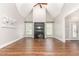 Living room with a vaulted ceiling and a cozy fireplace between windows, all complemented by hardwood floors at 2945 Chimney Hill Trl, Rocky Mount, NC 27804