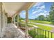 Covered porch with stone flooring, white columns, and black railing, offering a scenic view of the outdoors at 2945 Chimney Hill Trl, Rocky Mount, NC 27804