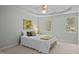 Well-lit bedroom with a tray ceiling, two windows, and neutral carpet and walls at 308 Fleming Dr, Durham, NC 27712