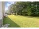 Large backyard of home with newly mowed grass and exterior of home to the side at 308 Plaza Dr, Garner, NC 27529