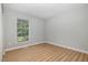 Clean, light-filled bedroom with wood-look flooring and a large window at 308 Plaza Dr, Garner, NC 27529