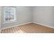 Bright bedroom featuring wood-look floors and a window with blinds at 308 Plaza Dr, Garner, NC 27529