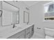 Bright bathroom featuring double vanity with gray cabinets and modern fixtures at 313 W Murray Ave, Durham, NC 27704
