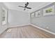 Bedroom featuring hardwood floors, a ceiling fan, three windows providing natural light, and board and batten accent wall at 313 W Murray Ave, Durham, NC 27704