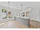 Modern kitchen featuring a gray island, white cabinets, stainless steel appliances, and pendant lighting at 313 W Murray Ave, Durham, NC 27704