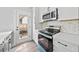 Kitchen features stainless steel appliances, white cabinets, tile backsplash, and backyard access at 313 W Murray Ave, Durham, NC 27704
