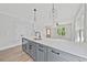 Bright kitchen with a large island, gray cabinets, modern lighting, and stainless steel appliances at 313 W Murray Ave, Durham, NC 27704