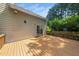 View of the wooden deck, sliding glass doors, and back of the house, surrounded by green trees at 316 Academia Ct, Durham, NC 27713
