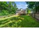 Spacious backyard with wooden deck, green lawn, surrounded by a wooded area and privacy fence at 316 Academia Ct, Durham, NC 27713