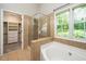 Bathroom featuring a walk-in shower, soaking tub and walk-in closet with custom shelving at 316 Academia Ct, Durham, NC 27713