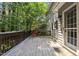 Back deck of home features an outdoor table and chairs with mature trees at 3306 Meadowrun Dr, Durham, NC 27707
