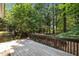 Home's wooden deck overlooks lush backyard greenery and mature shade trees at 3306 Meadowrun Dr, Durham, NC 27707