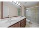 Bathroom with double sinks, a large mirror, and a tiled glass shower at 3306 Meadowrun Dr, Durham, NC 27707