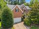Charming brick home boasts an attached garage and lush landscaping at 3306 Meadowrun Dr, Durham, NC 27707