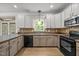 Well-lit kitchen with white cabinets, tile backsplash, and modern appliances at 3306 Meadowrun Dr, Durham, NC 27707