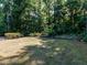 Wooded backyard featuring a small yard with mulched flower beds and forest views at 354 Crimson Way, Pittsboro, NC 27312