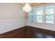 Spacious dining room featuring hardwood floors, a chandelier, and three large windows at 354 Crimson Way, Pittsboro, NC 27312
