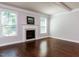 Bright living room featuring hardwood floors, a fireplace, and natural light, creating a warm and inviting atmosphere at 354 Crimson Way, Pittsboro, NC 27312