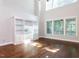 Bright living room features hardwood floors, built-in shelving, and large windows, creating a warm and inviting space at 354 Crimson Way, Pittsboro, NC 27312