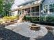 Outdoor patio area with a fire pit, steps leading to a screened porch, and lush landscaping at 354 Crimson Way, Pittsboro, NC 27312