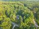 Aerial view of a house surrounded by dense, mature trees with a long winding driveway at 3650 Pleasants Ridge Dr, Wake Forest, NC 27587