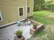 Inviting back patio featuring brick planters, two chairs, and a side table for outdoor relaxation and enjoyment at 3650 Pleasants Ridge Dr, Wake Forest, NC 27587