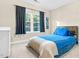 Bedroom showcasing a blue bed with a patterned coverlet, complemented by dark curtains and natural light at 3650 Pleasants Ridge Dr, Wake Forest, NC 27587