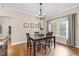 Elegant dining room features a modern chandelier, beautiful hardwood floors, and bright natural light at 3650 Pleasants Ridge Dr, Wake Forest, NC 27587
