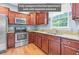 Galley kitchen featuring stainless steel appliances, granite countertops, and wood cabinets and flooring at 3650 Pleasants Ridge Dr, Wake Forest, NC 27587