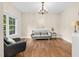 Comfortable living room featuring hardwood floors, a modern chandelier and ample natural lighting at 3650 Pleasants Ridge Dr, Wake Forest, NC 27587