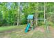 Backyard play area features a wooden playset with a slide, swing, climbing frame and is surrounded by trees at 3650 Pleasants Ridge Dr, Wake Forest, NC 27587