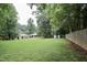 Spacious backyard featuring a well-maintained lawn, mature trees, and fencing at 3812 Vesta Dr, Raleigh, NC 27603