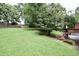 Backyard featuring a well-maintained lawn, mature trees, and small deck at 3812 Vesta Dr, Raleigh, NC 27603