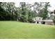 Expansive backyard with lush green lawn, mature trees, and house with garage at 3812 Vesta Dr, Raleigh, NC 27603