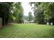 Expansive backyard with lush green lawn, mature trees, and surrounding properties at 3812 Vesta Dr, Raleigh, NC 27603