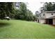 Spacious backyard featuring a well-maintained lawn, mature trees, and house with garage at 3812 Vesta Dr, Raleigh, NC 27603