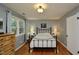 Comfortable bedroom with hardwood floors, an iron bed frame, and plenty of natural light at 3812 Vesta Dr, Raleigh, NC 27603