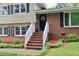 Close up of a front entrance to a two-story home, complete with brick steps and decorative wreath at 3812 Vesta Dr, Raleigh, NC 27603