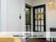 Bright entryway features a black door with glass panels and a wreath, white walls, and dark floors at 407 Coolidge St # A, Chapel Hill, NC 27516