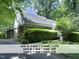 Exterior view of the triplex showing brick and white siding and mature trees at 407 Coolidge St # A, Chapel Hill, NC 27516