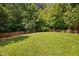 Spacious grassy backyard featuring a wooden fence and lush greenery at 413 Braxman Ln, Holly Springs, NC 27540