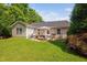 Beautiful backyard patio with seating area, umbrella, and well-manicured lawn at 413 Braxman Ln, Holly Springs, NC 27540