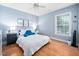 Tranquil bedroom with light blue walls, wood floors, and ample natural light from a window at 413 Braxman Ln, Holly Springs, NC 27540