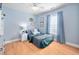Inviting bedroom with wood floors, a window, and a comfortable bed with stylish accents at 413 Braxman Ln, Holly Springs, NC 27540