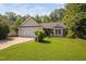 Charming single-story home featuring a well-maintained lawn and two-car garage at 413 Braxman Ln, Holly Springs, NC 27540