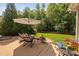 Inviting backyard patio with comfortable seating around a fire pit, surrounded by lush greenery at 413 Braxman Ln, Holly Springs, NC 27540