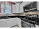 Close up of oven, microwave, sink, white cabinetry, and granite countertop at 428 Mill Station Ln, Wendell, NC 27591