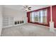 Carpeted living room with built-in shelving, accent wall, and a ceiling fan at 428 Mill Station Ln, Wendell, NC 27591