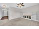 Carpeted living room featuring built-in shelving, a ceiling fan, and access to hallway at 428 Mill Station Ln, Wendell, NC 27591
