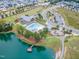 Aerial view of a serene community pond with a fishing pier, pool, clubhouse, and well-maintained landscaping at 428 Mill Station Ln, Wendell, NC 27591
